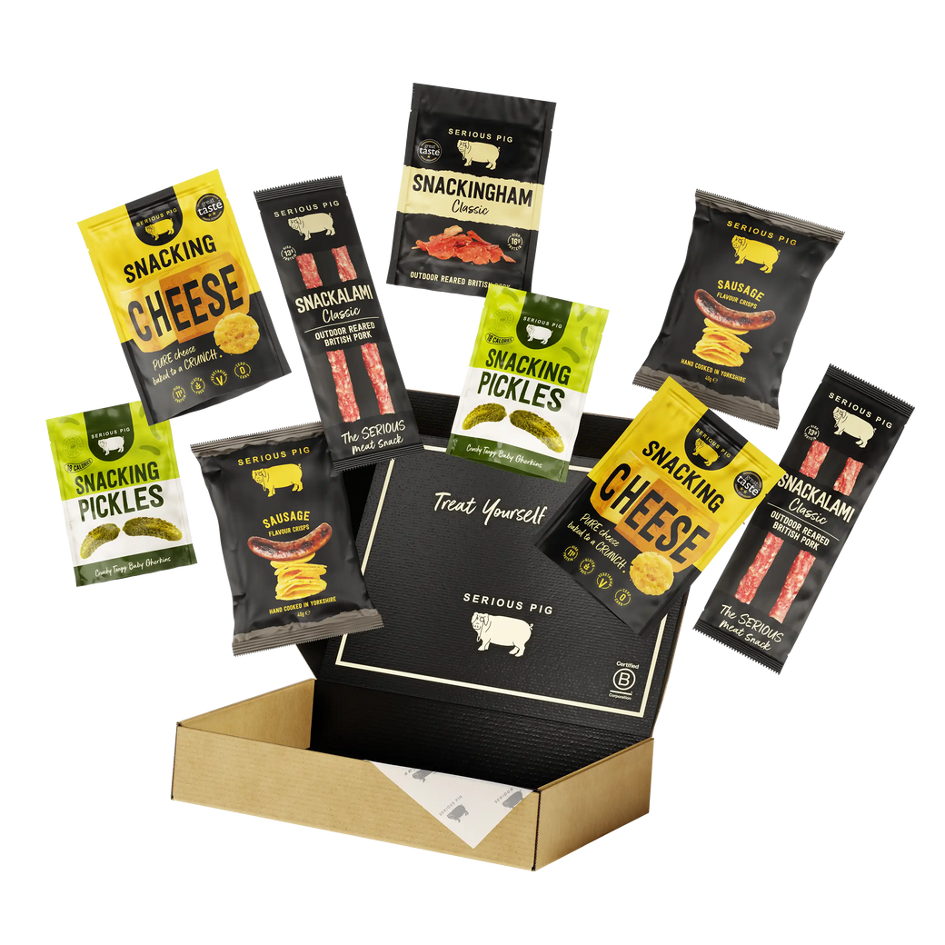 A snack assortment gift set from Serious Pig, featuring cheese, pickles, and sausages displayed in an open cardboard box against a white background.