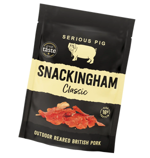 A bag of Serious Pig Snackingham Classic outdoor reared British pork snacks, in a black resealable pouch with a cream-colored band and product photo on a white background.
